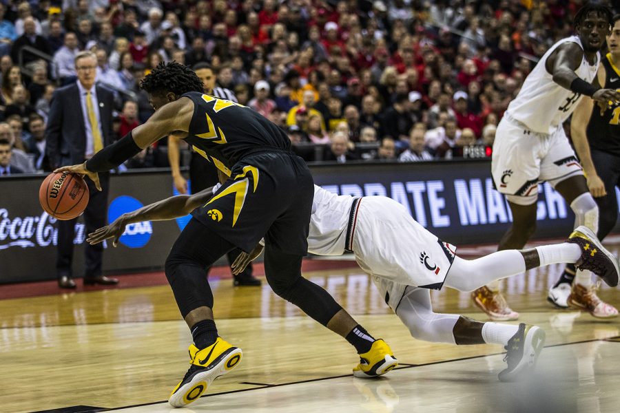 Iowa forward Tyler Cook and Cincinnati forward Trevon Scott run for the ball during the NCAA game against Cincinnati at Nationwide Arena on Friday, March 22, 2019. The Hawkeyes defeated the Bearcats 79-72.