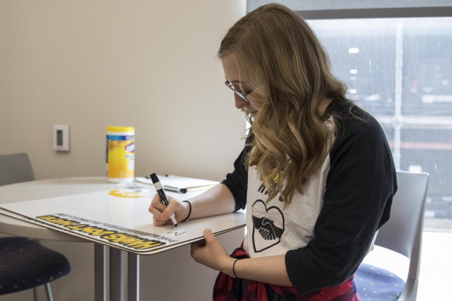 Student Elizabeth Strey writes on a whiteboard during Hawks Dont Hate outside the Catlett Dining Hall on Monday, March 25, 2019. Hawks Dont Hate aims to address stereotypes on campus by giving students a chance to share their stories. This comes weeks after the popular hashtag #doesuiowaloveme, which looked at discrimination on campus.