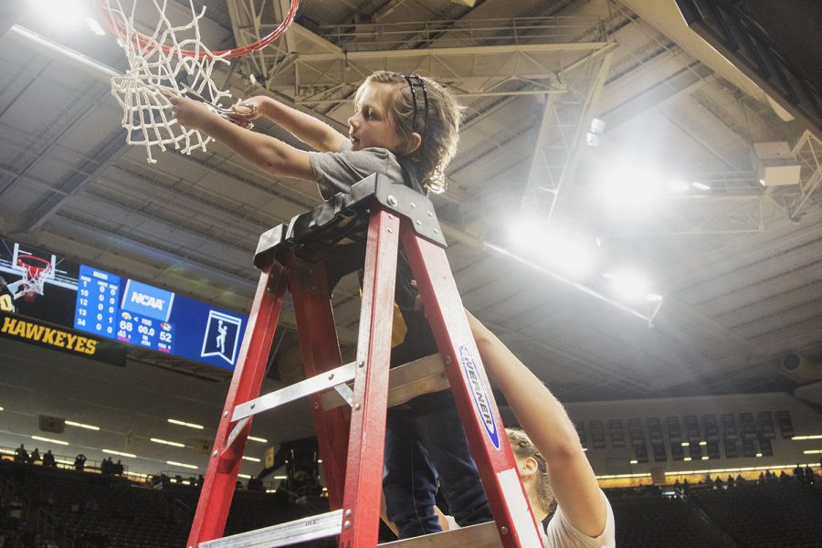 Harper Stribe cuts down a piece of net with the support of Iowa guard Kathleen Doyle after the Iowa/Mizzou NCAA Tournament second round womens basketball game in Carver-Hawkeye Arena  on Sunday, March 24, 2019. The Hawkeyes defeated the Tigers, 68-52. 