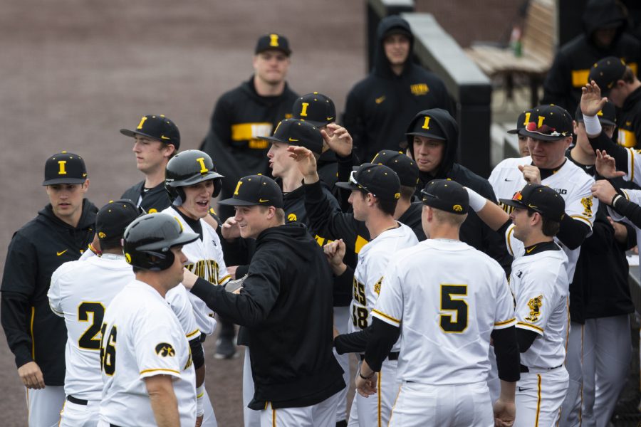 Iowa catcher Austin Martin is congratulated as he walks back to the dugout after scoring the first run of the game. The Hawkeyes defeated the Illini 8-4 at Duane Banks Field on Mar 29, 2019. 