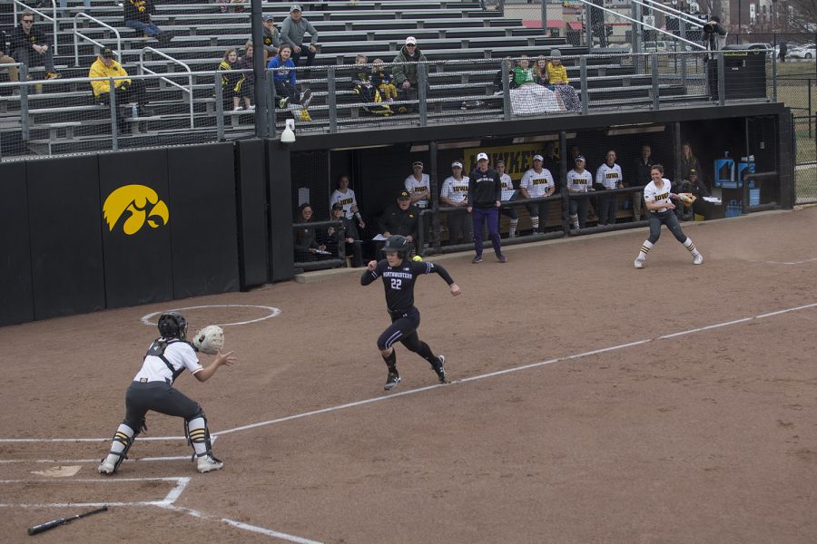 Northwestern outfielder Emma Bartz races the ball to home plate during the second inning of the conference opening softball game at Pearl Field on Friday, March 29, 2019. Bartz beat the ball to the plate, scoring the only run of the inning. The Wildcats defeated the Hawkeyes 5-1. 