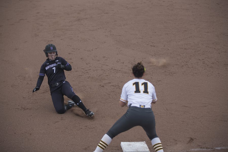 Northwestern fielder Morgan Nelson slides into third during the conference opening softball game at Pearl Field on Friday, March 29, 2019. Nelson successfully made it on base but did not score a run within the inning. The Wildcats defeated the Hawkeyes 5-1.