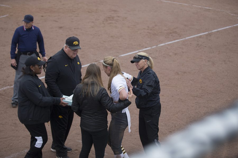 Iowa coaches support starting pitcher Allison Doocy (JR) after she suffered a minor injury during the fourth inning of the conference opening softball game at Pearl Field on Friday, March 29, 2019. The Wildcats defeated the Hawkeyes 5-1. 