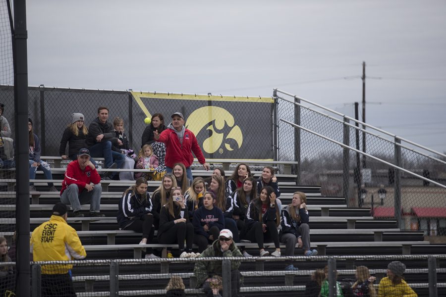 A fan throws one of many foul balls to event staff during the conference opening softball game at Pearl Field on Friday, March 29, 2019. The Wildcats defeated the Hawkeyes 5-1. 