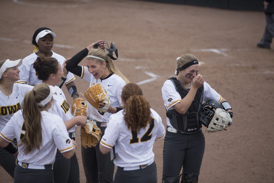 Hawkeyes celebrate pitcher Allison Doocy's quick recovery from fourth inning injury during the conference opening softball game at Pearl Field on Friday, March 29, 2019. The Wildcats defeated the Hawkeyes 5-1. 