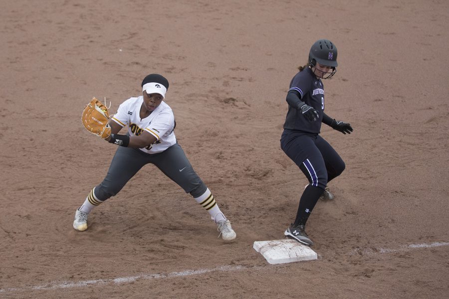 Iowa infielder Donirae Mayhew catches the ball to stop Northwestern's Lily Novak from stealing first during the conference opening softball game at Pearl Field on Friday, March 29, 2019. The Wildcats defeated the Hawkeyes 5-1. 