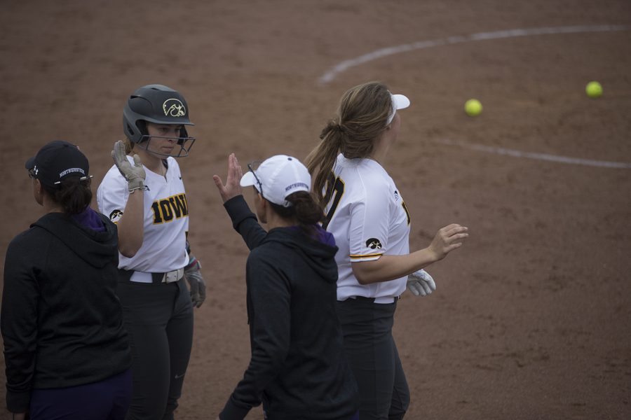 Iowa infielder Sydney Owens high fives Norhwestern head coach Kate Drohan at the end of the conference opening softball game at Pearl Field on Friday, March 29, 2019. The Wildcats defeated the Hawkeyes 5-1.