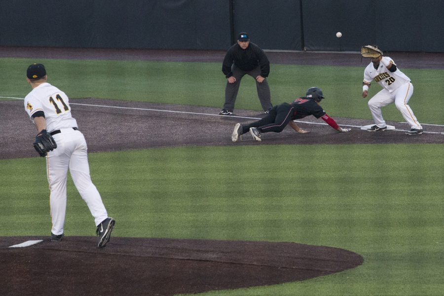 Iowa pitcher Cole McDonald tries to throw out Rutgers' Kevin Blum at first at the Iowa vs Rutgers game at Duane Banks Field on Friday, April 4, 2019. Blum beat Fullard back to the plate. The Hawkeyes defeated the Scarlet Knights 6-1.