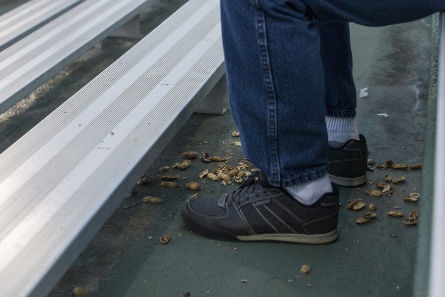 Peanut shells accumulate an Iowa fan's feet at the Iowa vs Rutgers game at Duane Banks Field on Friday, April 4, 2019. The Hawkeyes defeated the Scarlet Knights 6-1.