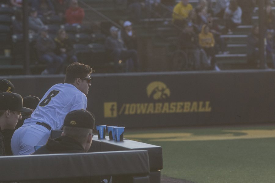 Iowa outfielder Luke Farley watches a play with teammates next to the dugout at the Iowa vs Rutgers game at Duane Banks Field on Friday, April 4, 2019. The Hawkeyes defeated the Scarlet Knights 6-1.