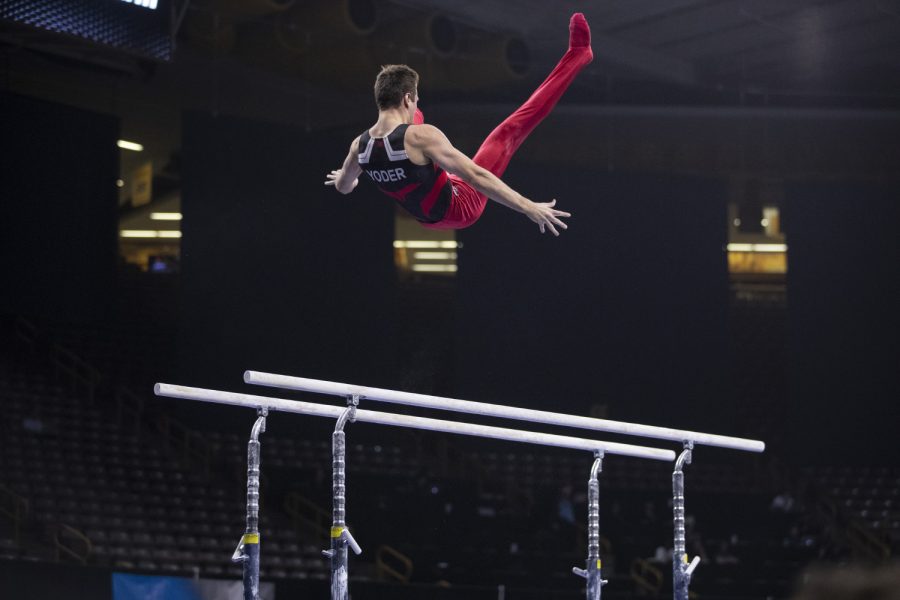 Ohio State gymnast Alec Yoder competes in the parallel bars Friday in Carver Hawkeye Arena during the Men's Big Ten Championships. Penn State won the team competition with a combined score of 410.350 points.