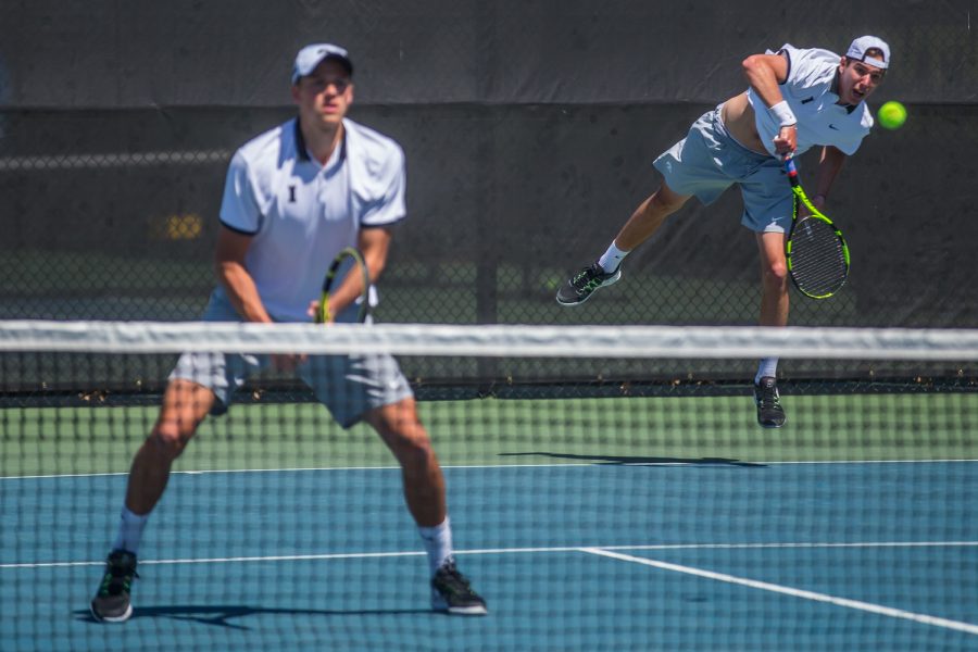 Iowa's Nikita Snezhko hits a serve during a men's tennis match between Iowa and Michigan at the HTRC on Sunday, April 21, 2019. The Hawkeyes, celebrating senior day, defeated the Wolverines, 4-1.