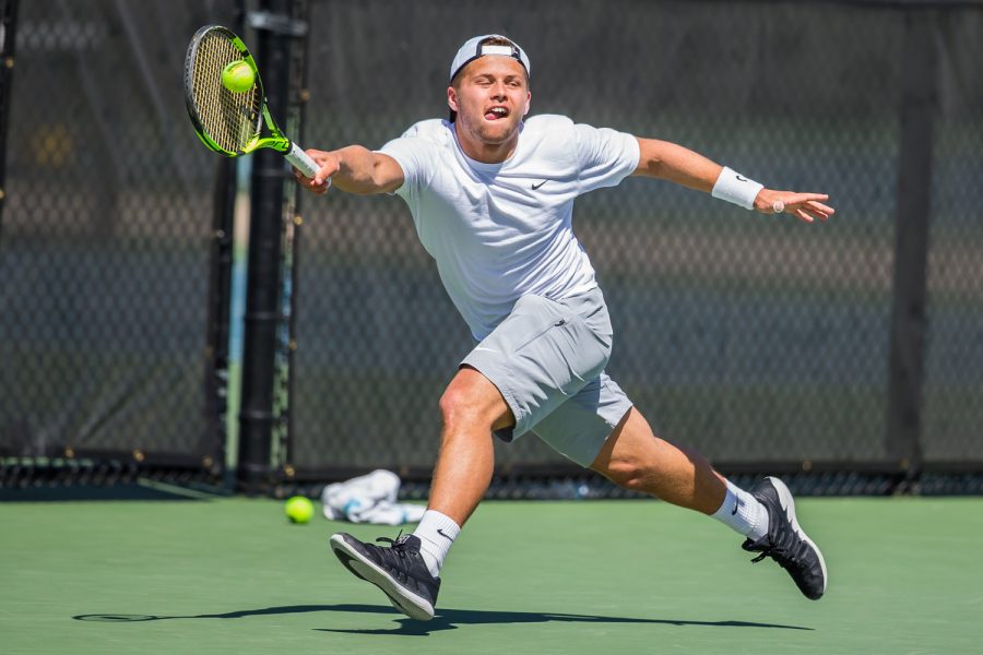 Iowa's Will Davies hits a forehand during a men's tennis match between Iowa and Michigan at the HTRC on Sunday, April 21, 2019. The Hawkeyes, celebrating senior day, defeated the Wolverines, 4-1.