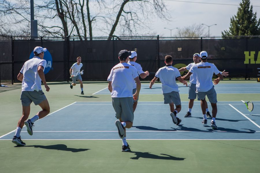 Iowa players run to celebrate Will Davies' win during a men's tennis match between Iowa and Michigan at the HTRC on Sunday, April 21, 2019. The Hawkeyes, celebrating senior day, defeated the Wolverines, 4-1.