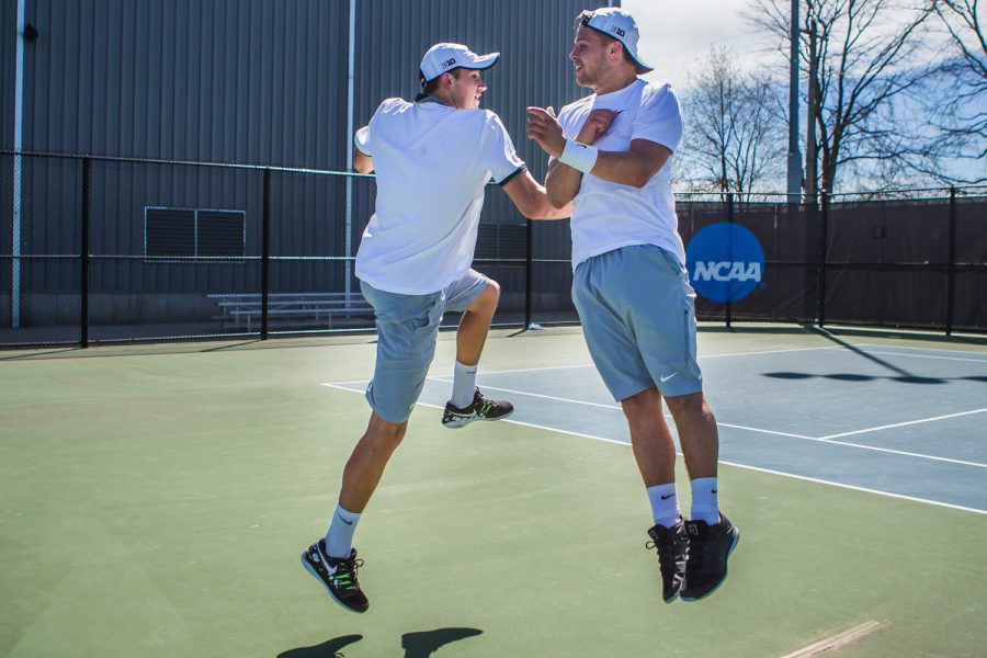 Iowa's Joe Tyler shoulder-bumps teammate Will Davies during a men's tennis match between Iowa and Michigan at the HTRC on Sunday, April 21, 2019. The Hawkeyes, celebrating senior day, defeated the Wolverines, 4-1.