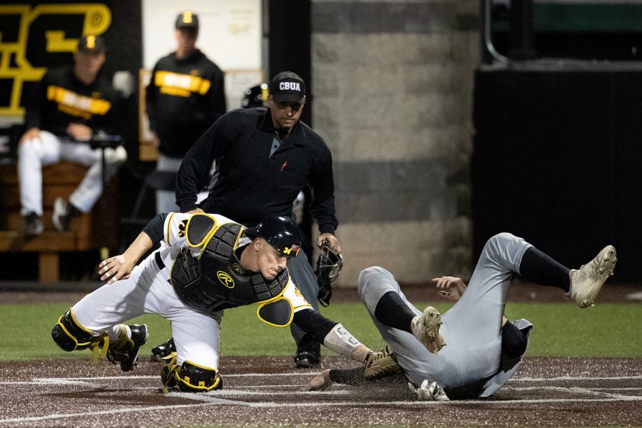 Iowa catcher Austin Martin tags out  Milwaukee catcher Tyler Bordner during the baseball game against Milwaukee at Duane Banks Field on Tuesday, April 23, 2019. The Hawkeyes defeated the Panthers 5-4.