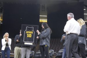 Megan Gustafson holds her framed jersey, which will be retired.