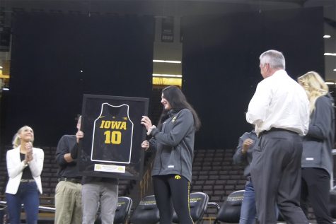 Megan Gustafson holds her framed jersey, which will be retired.