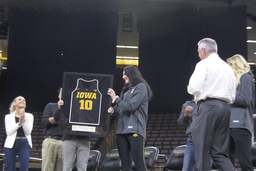 Megan+Gustafson+holds+her+framed+jersey%2C+which+will+be+retired.