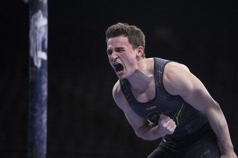 Hawkeye gymnast Jake Brodarzon celebrates after competing in the parallel bars Friday in Carver Hawkeye Arena during the Mens Big Ten Championships. Penn State won the team competition with a combined score of 410.350 points.