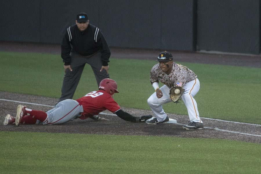 Nebraska's Cam Chick slides back to first as Iowa's Izaya Fullard catches the ball during a baseball game against Nebraska in Duane Banks Field on April 19, 2019. The Hawkeyes defeated the Cornhuskers 3-2.