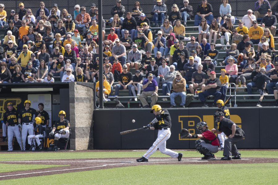 Iowa catcher Austin Martin hits the ball but gets called out on first during the first inning of the afternoon Iowa vs Rutgers game at Duane Banks Field on Saturday, April 7, 2019. The Hawkeyes defeated the Scarlet Knights 9-5.