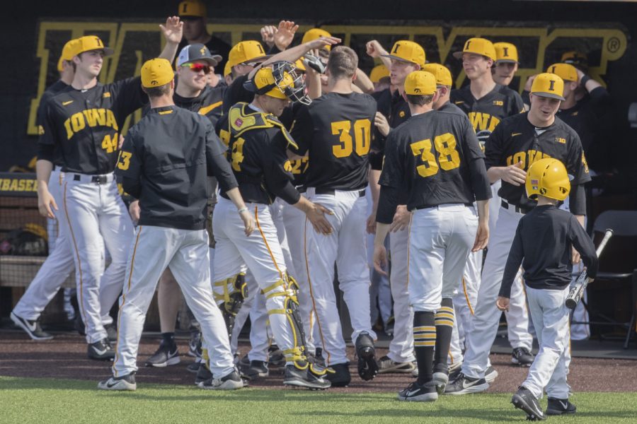 Iowa Hawkeyes congratulate fielder Connor McCaffery on a run during the fourth inning of the afternoon Iowa vs Rutgers game at Duane Banks Field on Saturday, April 7, 2019. The Hawkeyes defeated the Scarlet Knights 9-5.