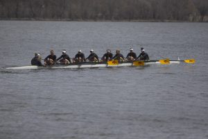 The Iowa varsity 8 crew looks to their supporters on the shore as they row back to the dock at the end of the first session of a womens rowing meet on Lake MacBride on Saturday April 13, 2019. 