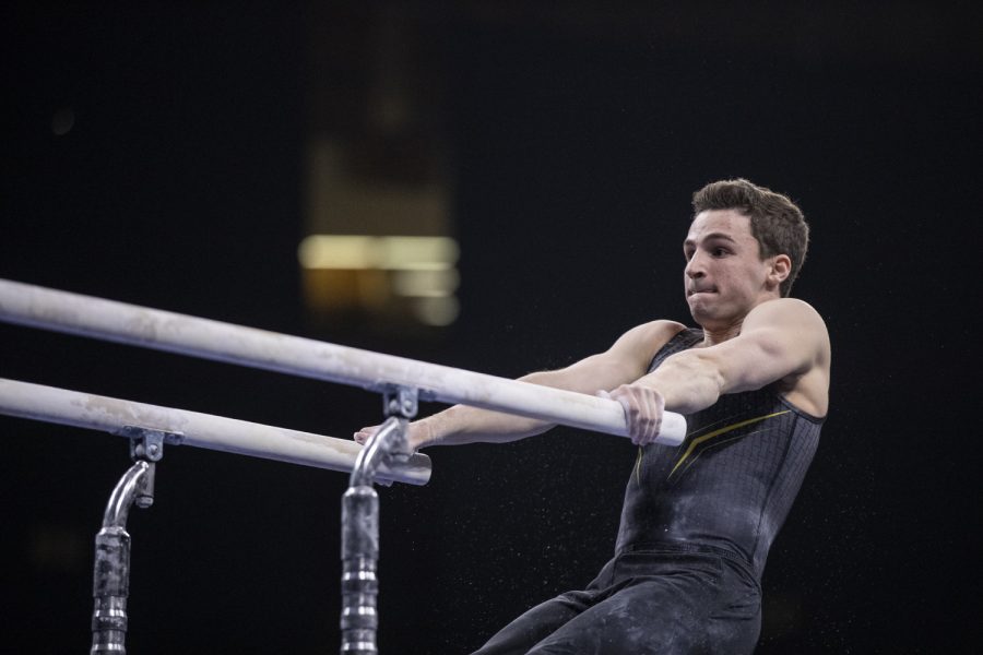 Hawkeye gymnast Jake Brodarzon competes in the parallel bars Friday in Carver Hawkeye Arena during Mens Big Ten Championships. Penn State won the team competition with a combined score of 410.350 points. (Ryan Adams/The Daily Iowan)