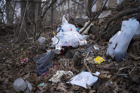 Litter is photographed on a hillside off of Riverside Drive near the theater building on Monday, March 25, 2019.