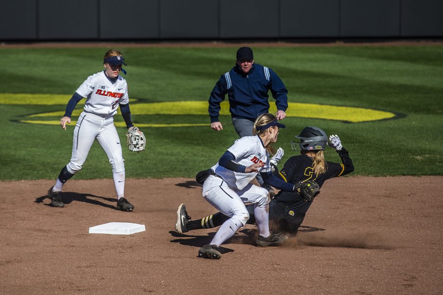 Iowa utility player Aralee Bogar slides into second base and is announced safe during the game against Illinois at the Bob Pearl Softball Field on Saturday, April 13, 2019. The Hawkeyes defeated the Fighting Illini 4-3.
