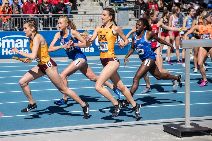 Runners exchange batons during the university women's 4x1600m race at the 2019 Drake Relays in Des Moines, IA, on Friday, April 26, 2019.