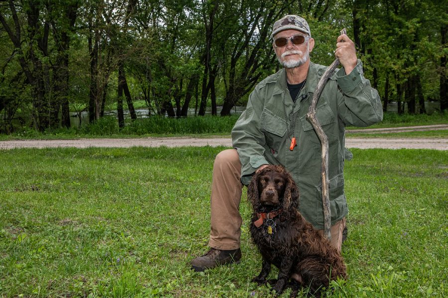 Former Clarion Art Teacher and Wrestling Coach Jack Britton stands with his dog Razor near the Iowa River bank at Pikes Timber on May 22, 2019. Britton was in the area looking for morel mushrooms. 