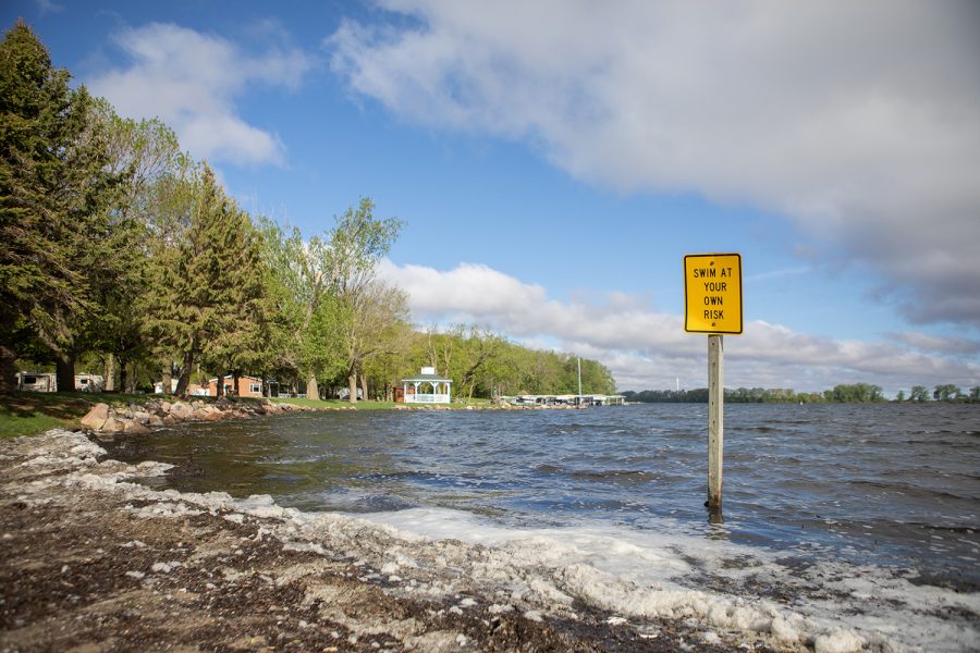 A sign marked “Swim at your own risk”  stands as a warning that no lifeguard monitoring the waters along the shore of Crystal Lake on May 20, 2019. During the river expedition, Crystal Lake marks the beginning of the 329-mile Iowa River. The nitrate levels in the lake were approximately 25mg/L.