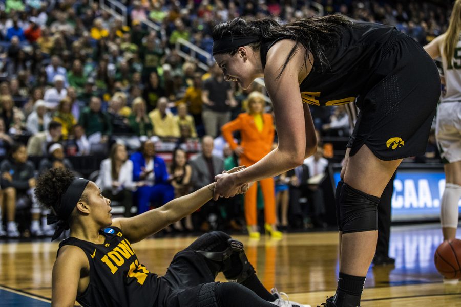 Iowa center Megan Gustafson helps up guard Tania Davis during the NCAA Elite 8 game against Baylor at the Greensboro Coliseum Complex on Monday, April 1, 2019. The Bears defeated the Hawkeyes 85-53.