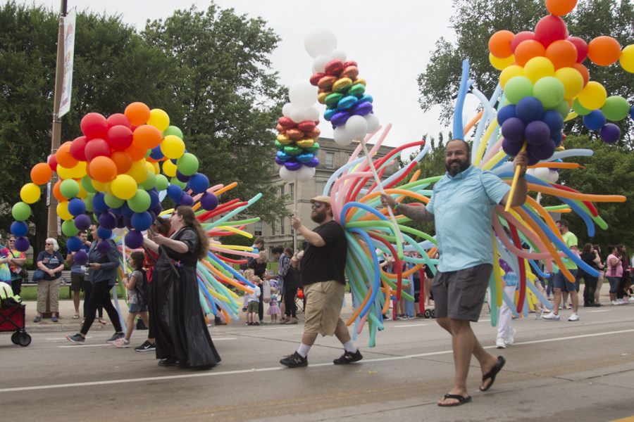People walk in the Iowa City Pride parade parade with colorful balloons at Iowa City Pride on Saturday, June 15, 2019. 