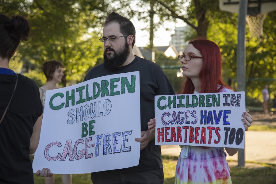 Participants hold posters during the “Lights for Liberty: Vigil to End Human Concentration Camps” at College Green Park on Friday, July 12, 2019. (Tian Liu/The Daily Iowan)