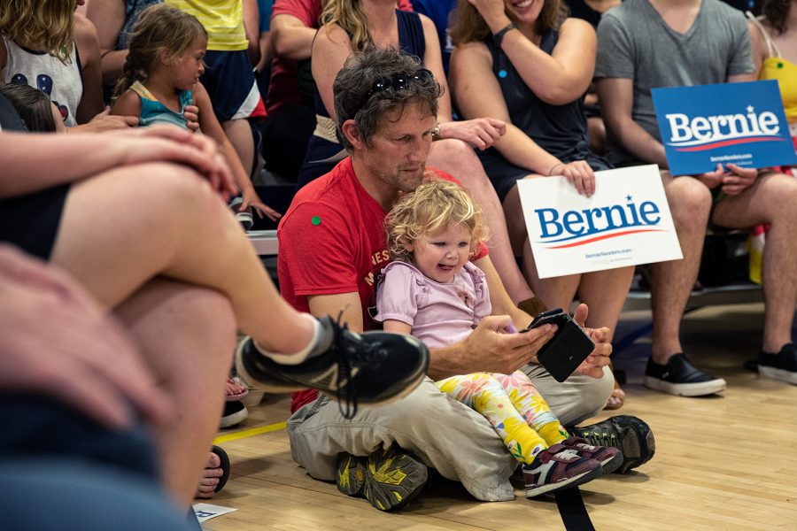 A supporter entertains his crying child during an ice cream social, Tuesday, July 2, 2019, at the Robert A. Lee Recreation Center in Iowa City, Iowa.