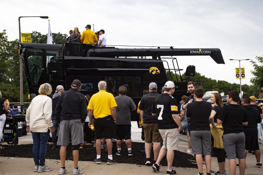 Hawkeye fans take turns taking pictures of the Iowa Corn tractor outside of Kinnick Stadium on August 31, 2019.