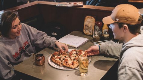 Students Grant Clampitt and Kate Holstrum share a heart-shaped pizza for Valentines Day at The Airliner Bar-Iowa City on Thursday. Every year The Airliner serves their famous pizza  in the shape of a heart for the holiday. 