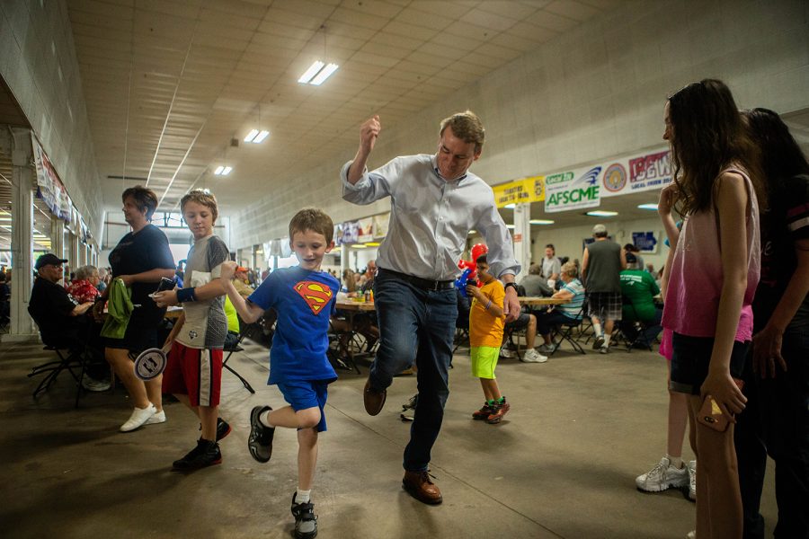 Liam Bogs (7) of Cedar Rapids teaches Sen. Michael Bennet, D-CO, during the Hawkeye Area Labor Council Picnic at Hawkeye Downs on Monday, September 2, 2019.
