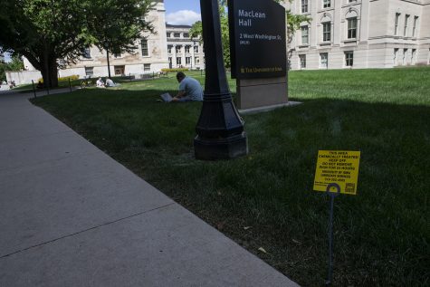 A sign warning students to stay off the grass sits on the Pentacrest on Sept. 4, 2019. Despite the warning about chemical treatment, some students continue to sit. 