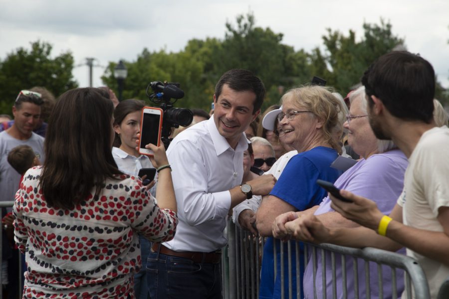 2020 Democratic candidate Pete Buttigieg smiles with an attendant during a lawn event to celebrate opening his new campaign office in downtown Iowa City on September 2, 2019.