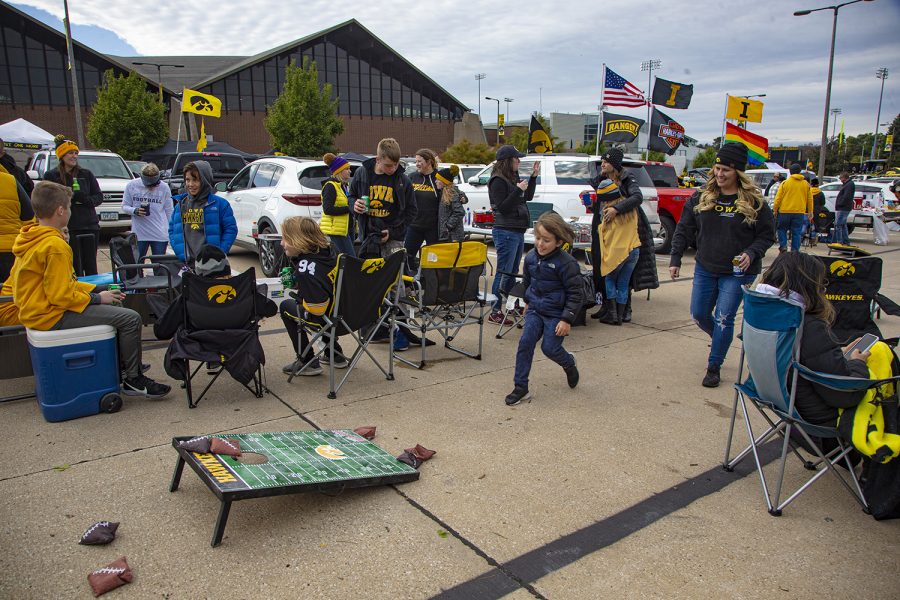 A mother and son play corn hole outside of Hawkeye Carver arena before the Hawkeyes take on Penn State on Oct. 12. 