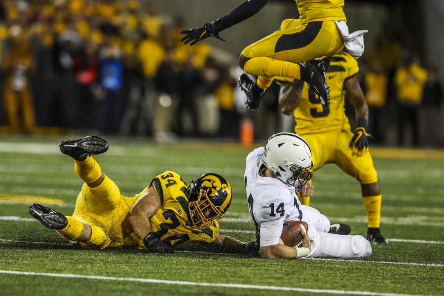 Iowa linebacker Kristian Welch reaches for Penn State quarterback Sean Clifford during the Iowa football game against Penn State in Iowa City on Saturday, Oct. 12, 2019. The Nittany Lions lead the Hawkeyes 7-6 at half.