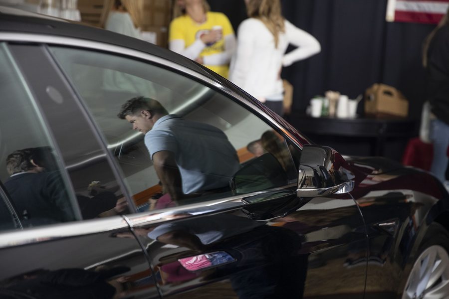 Business owner Jason Hall talks to attendees next to a Tesla at Moxie Solar in North Liberty, IA, on Friday, Oct. 18, 2019. The visit was part of John Delaney’s Heartland Startup Tour. (Jenna Galligan/The Daily Iowan)