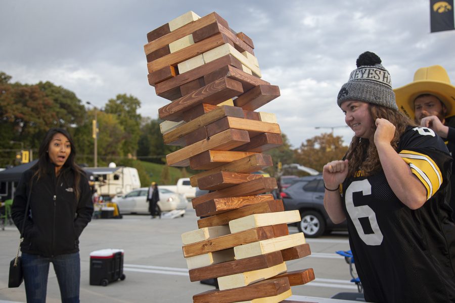 Fans watch Jenga tower topple in the Hancher parking lot on Saturday, October 19th, 2019. The group of fans played games to get themselves excited for the Iowa vs. Purdue game during tailgate festivities. 