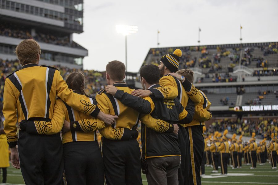 Members of the Iowa marching band listen to the alumni band play the Alma Mater during the Iowa football game against Purdue at Kinnick Stadium on Saturday, Oct. 19, 2019. The Hawkeyes defeated the Boilermakers 26-20. 