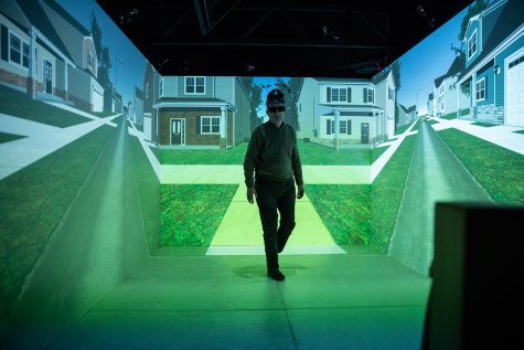 Hank Lab Co-Director Joe Kearney walks through one of the virtual reality environments wearing a headset with sensors attached at Hank Virtual Laboratory on October 24, 2019. The lab conducts research on pedestrian behavior, and has collaborated with companies such as Toyota. 