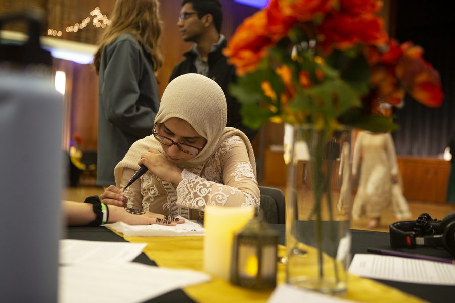 Amna Haider designs henna on the back of an attendee’s hand at Henna Night. Henna Night was hosted by the Pakistani Students Association and was held in the 2nd floor ballroom in the IMU. (Nichole Harris/The Daily Iowan)